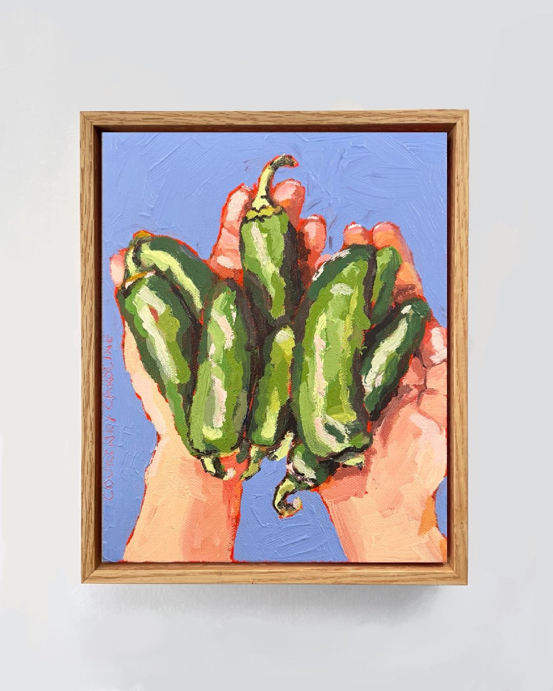 Acrylic and oil painting of two hands holding fresh jalapeño peppers with a textured blue background. Original artwork by Courtney Caroline