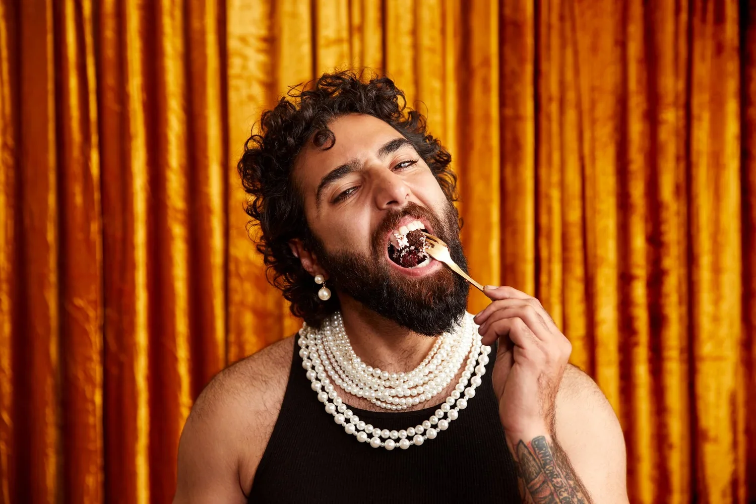 portrait-glamorous-pearls-man-eating-cake-marie-antoinette-gold-luxe-beard-curls.webp