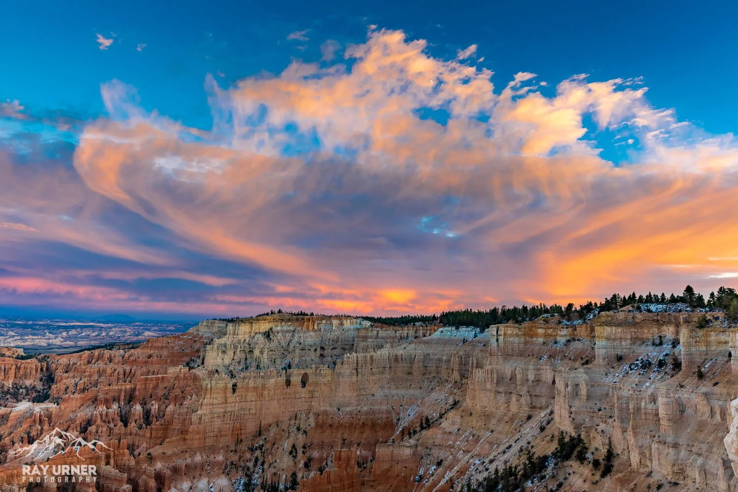 Sunset over the Grand Canyon with colorful sky and layered rock formations.