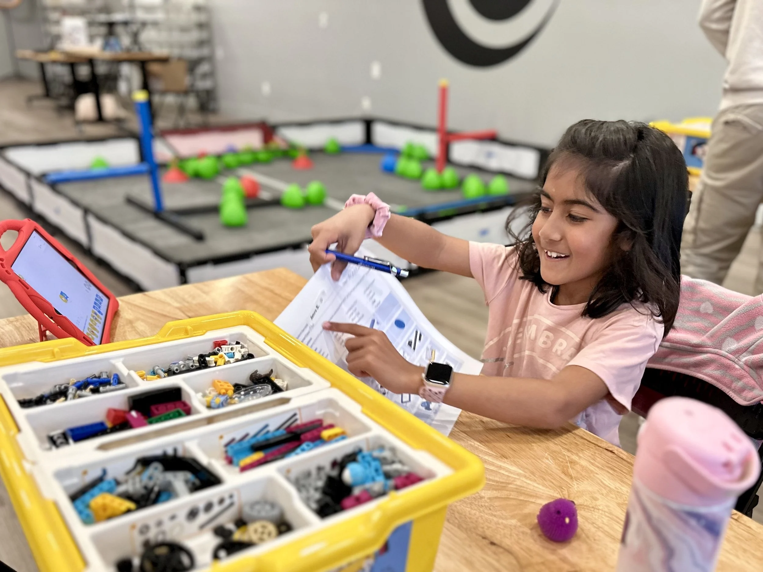 Elementary student building a VEX IQ robot at a Robolabs class