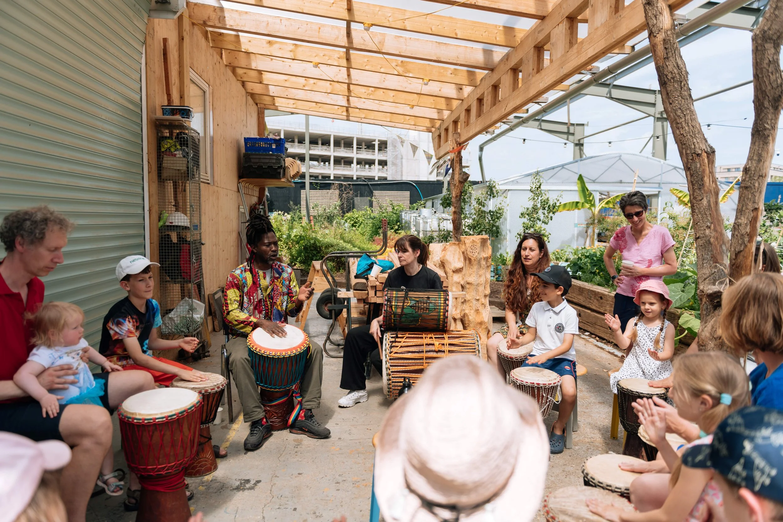 Young people drumming in a circle in a garden