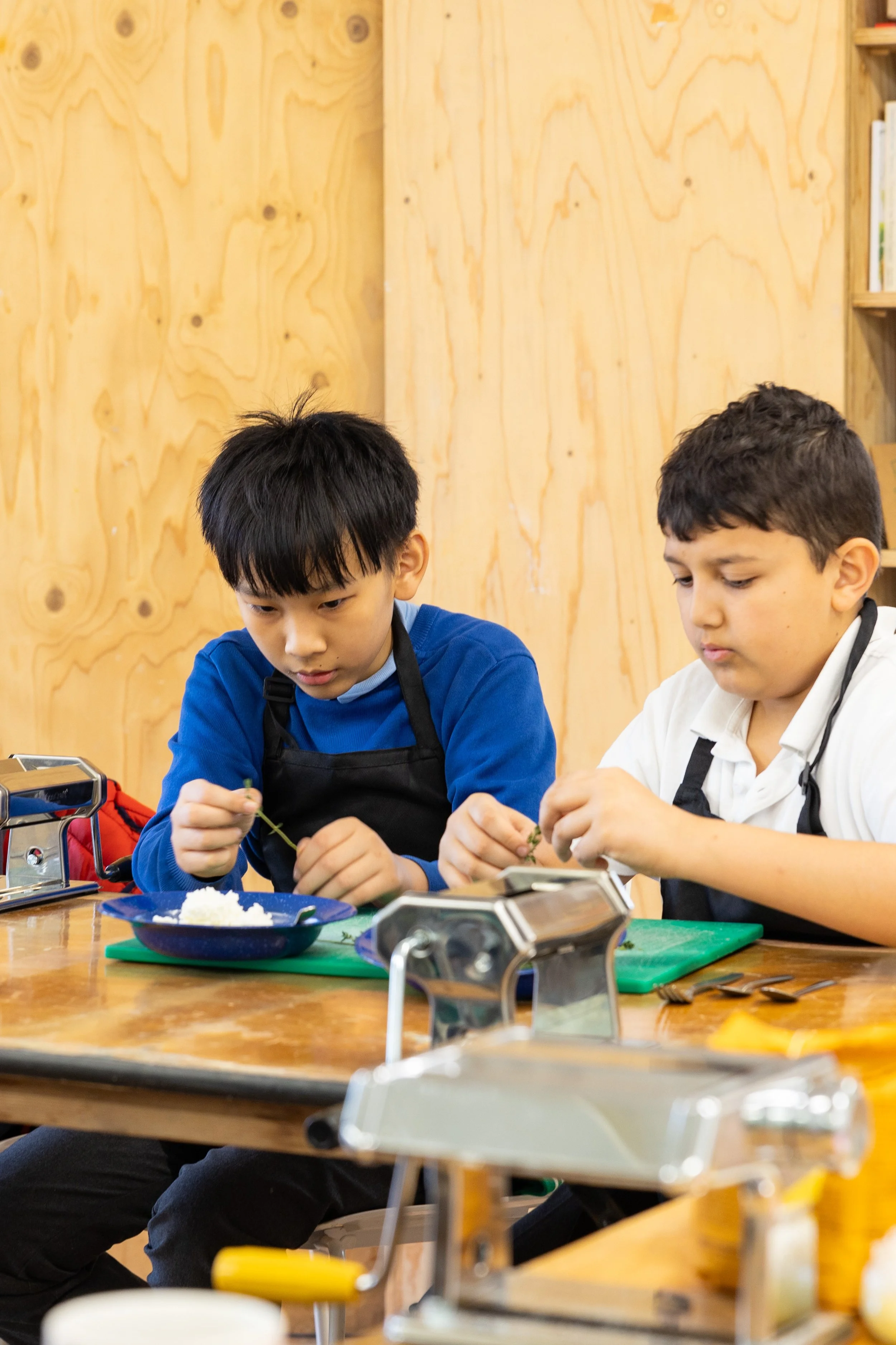 two students prepare herbs in a cooking session