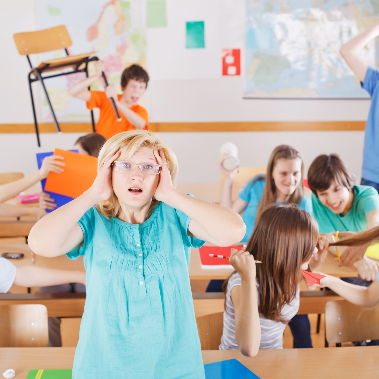 A classroom scene with a woman in the foreground holding her head with a worried expression, surrounded by children engaged in various activities like throwing paper airplanes and raising their hands, with maps on the wall behind.