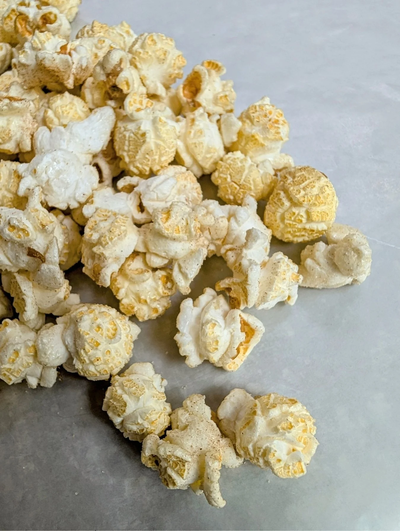 Close-up of many popped kernels of cinnamon sugar-coated kettle corn.