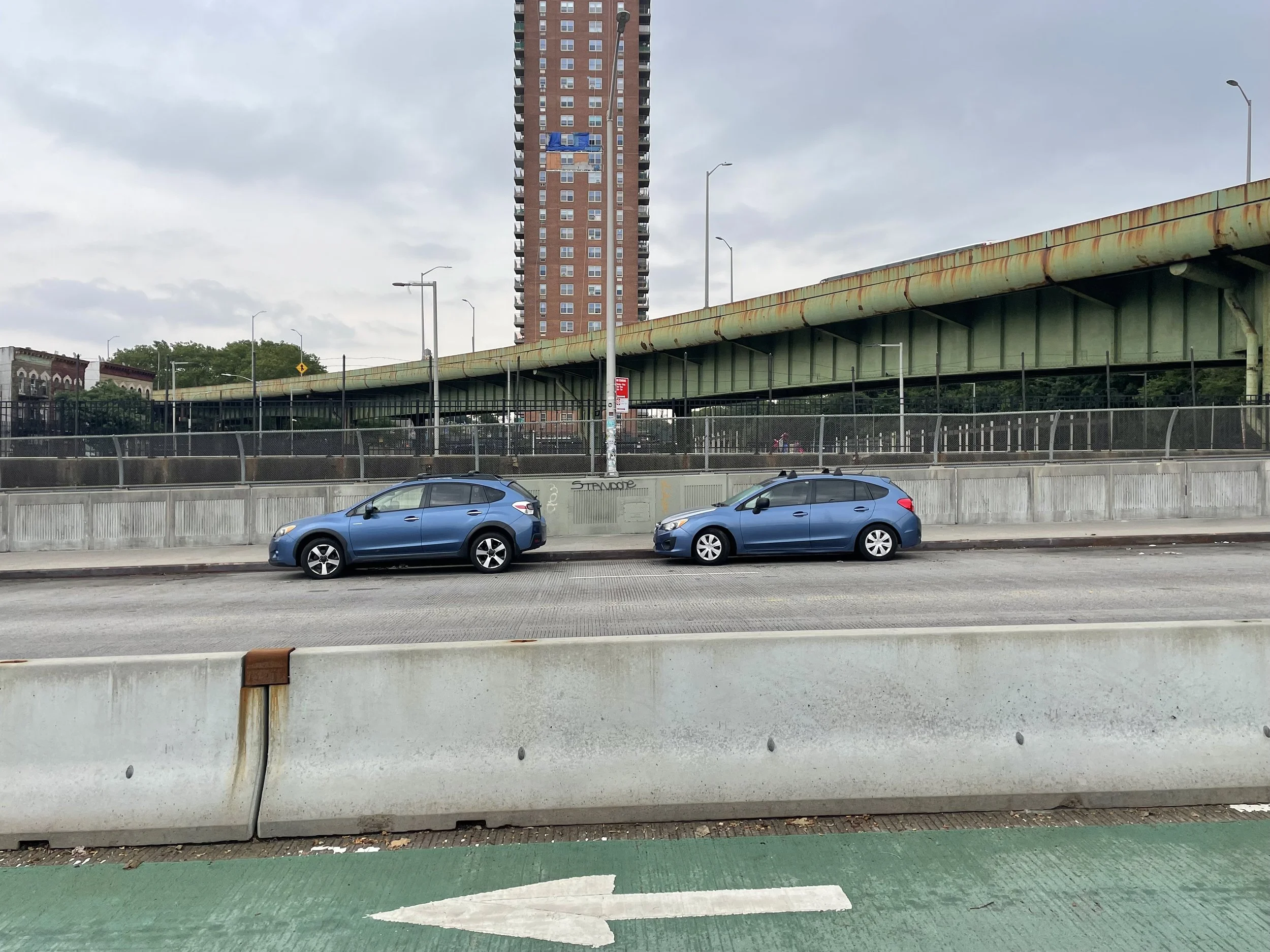 two cars mirror eachother in an otherwise "empty" scene of roadways and signages.
