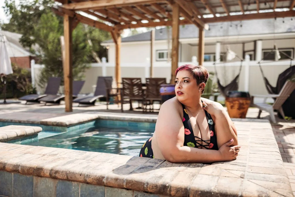 Woman relaxing at the edge of a pool during an outdoor boudoir photography session in Jacksonville, Florida