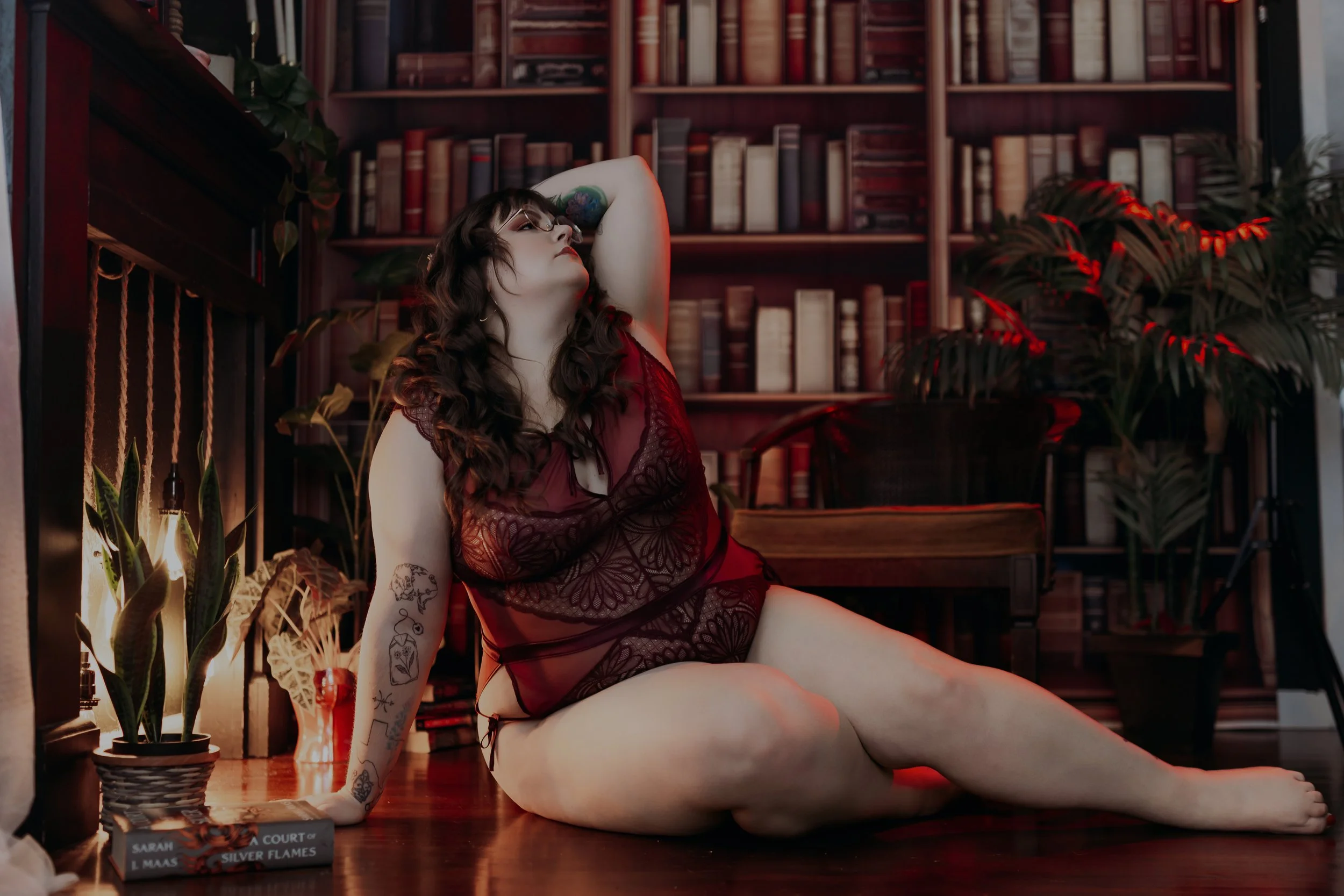 Woman in red lingerie posing in the dark library set at Hype Girl Boudoir in Jacksonville