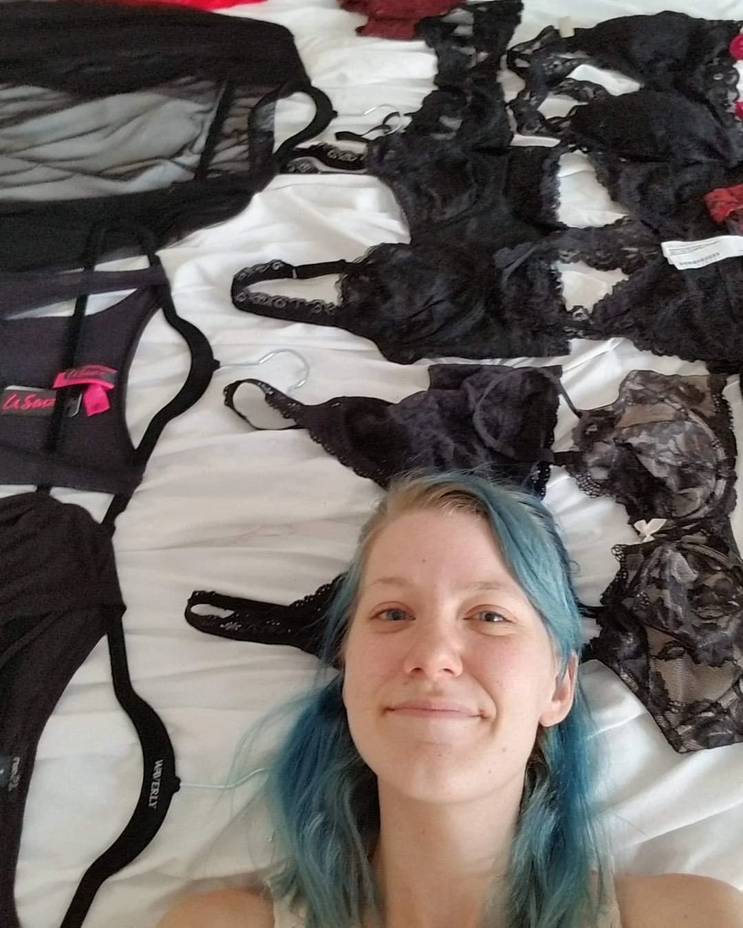 Tiffany Joyce lying beside a collection of lingerie during her years as a boudoir photographer