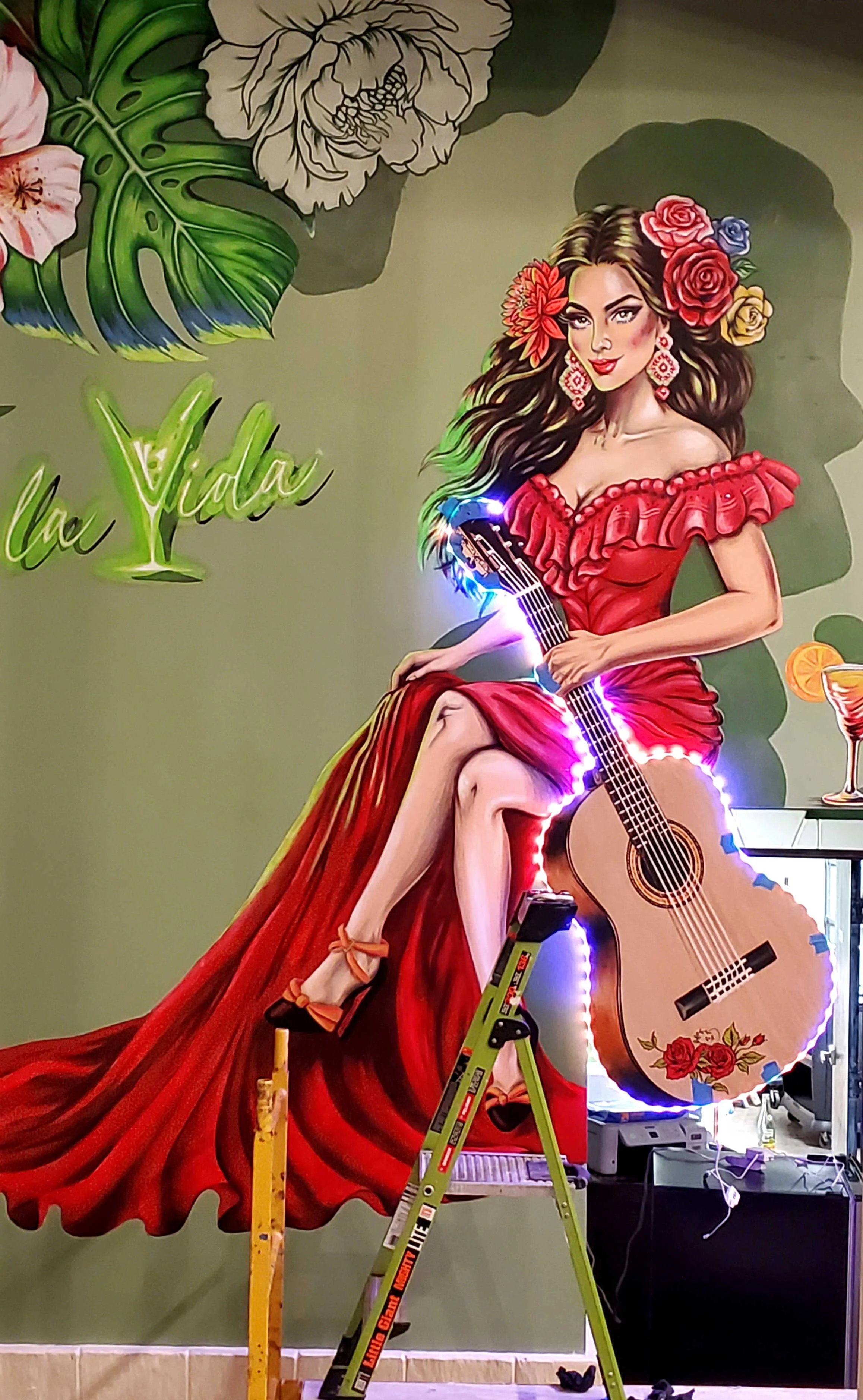 custom guitar cut-out with LED lights and mural of a woman in red dress