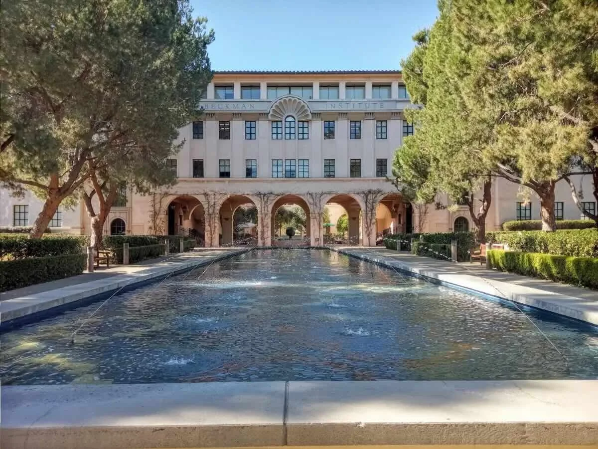 Caltech campus courtyard with academic buildings, landscaped lawn, and walkway between structures in Pasadena