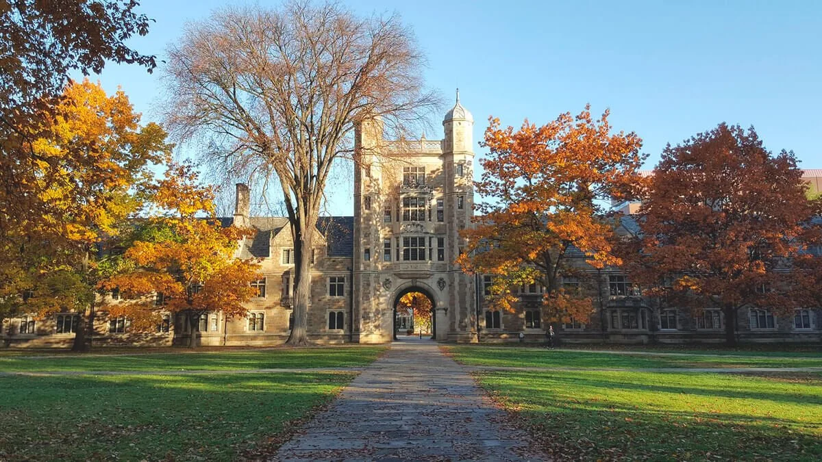University of Michigan Law Quadrangle in autumn with stone archway and colorful fall trees