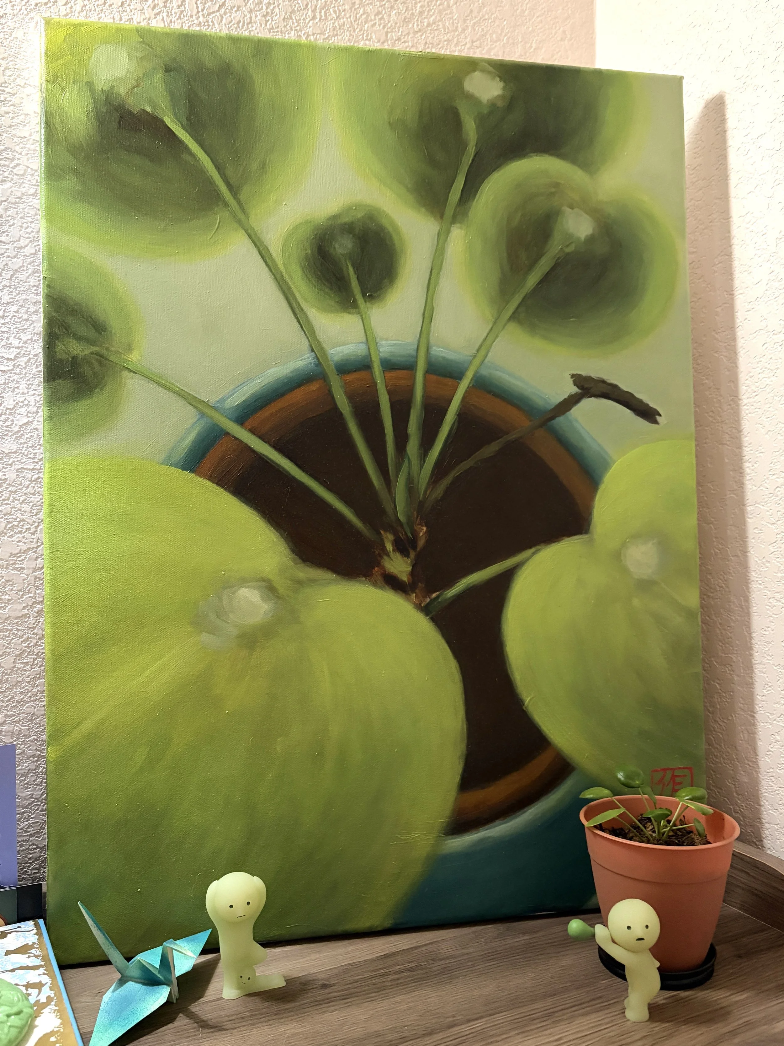 A picture of the painting of the 8 beside the real the 8, both displayed on top a bookshelf and accompanied by two Smiski figurines.