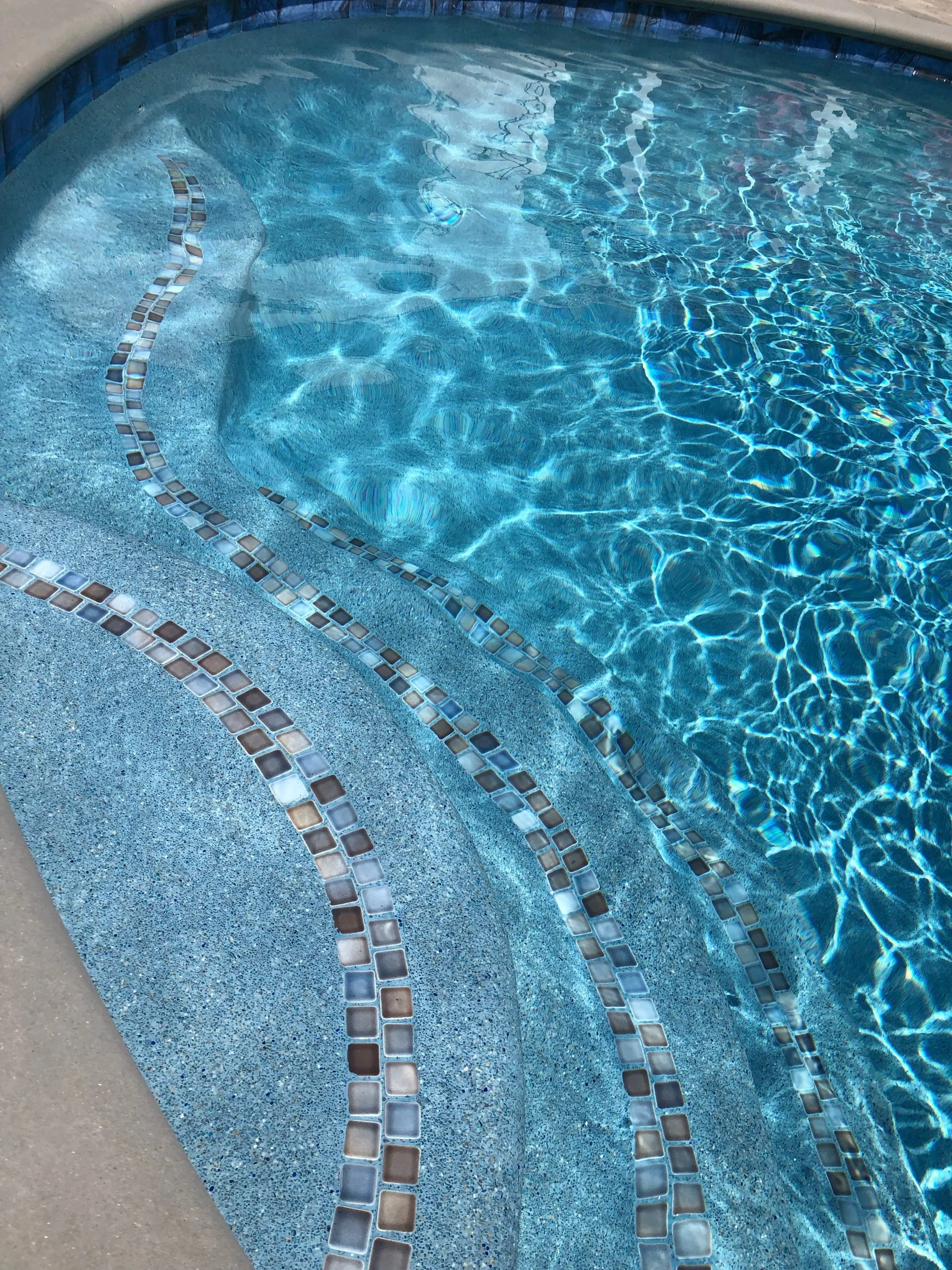 Pool Steps with Glass Tile Inlay and Pebble Finish