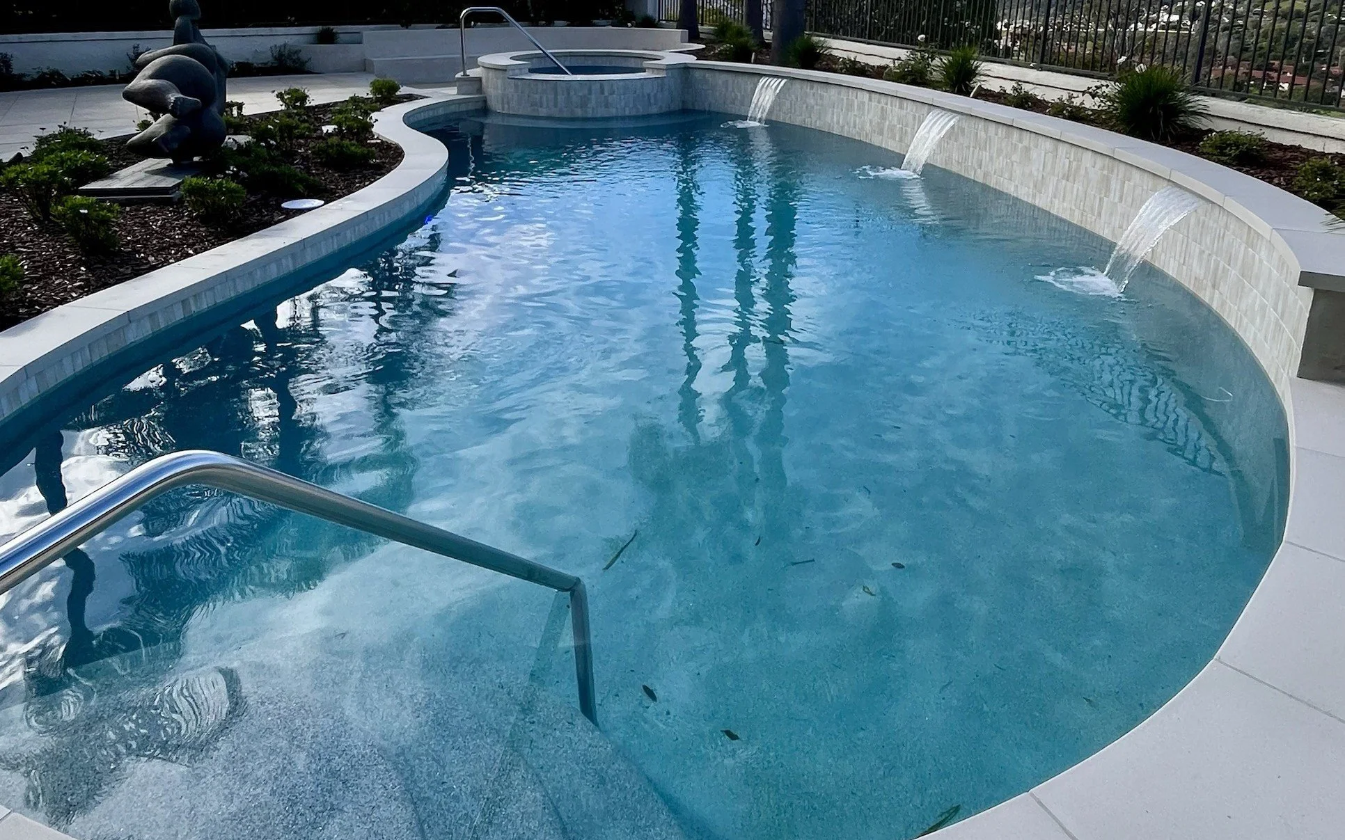 Custom pool and raised spa with tiled wall and sheer-descent water features in Orange County