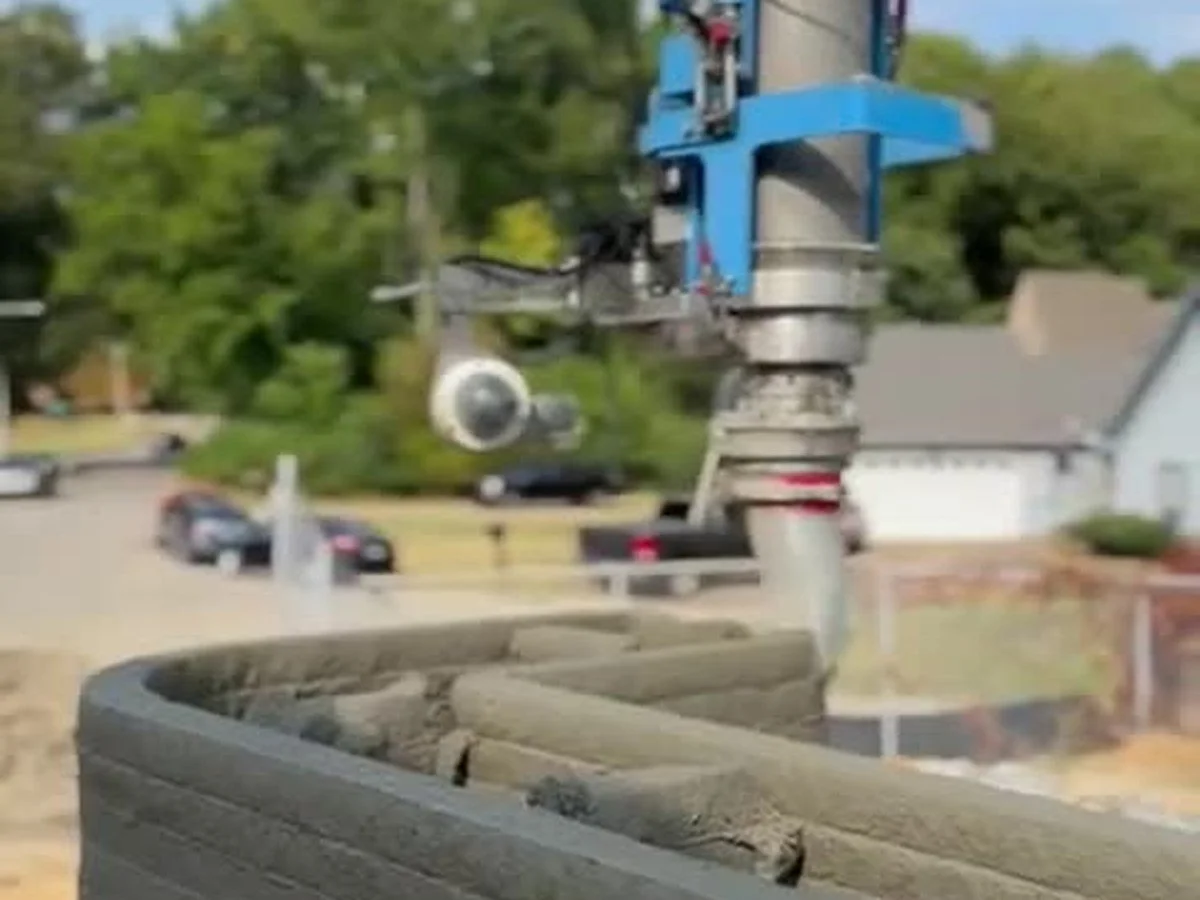 Robotic 3D concrete printer laying the curved wall of a new structure