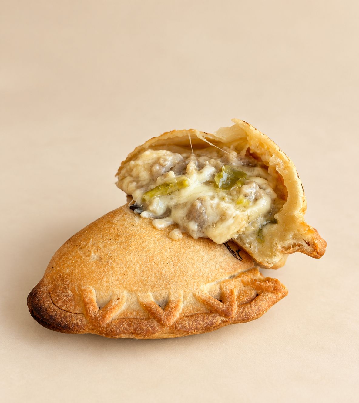 Half of a stuffed pastry with savory filling on decorative paper