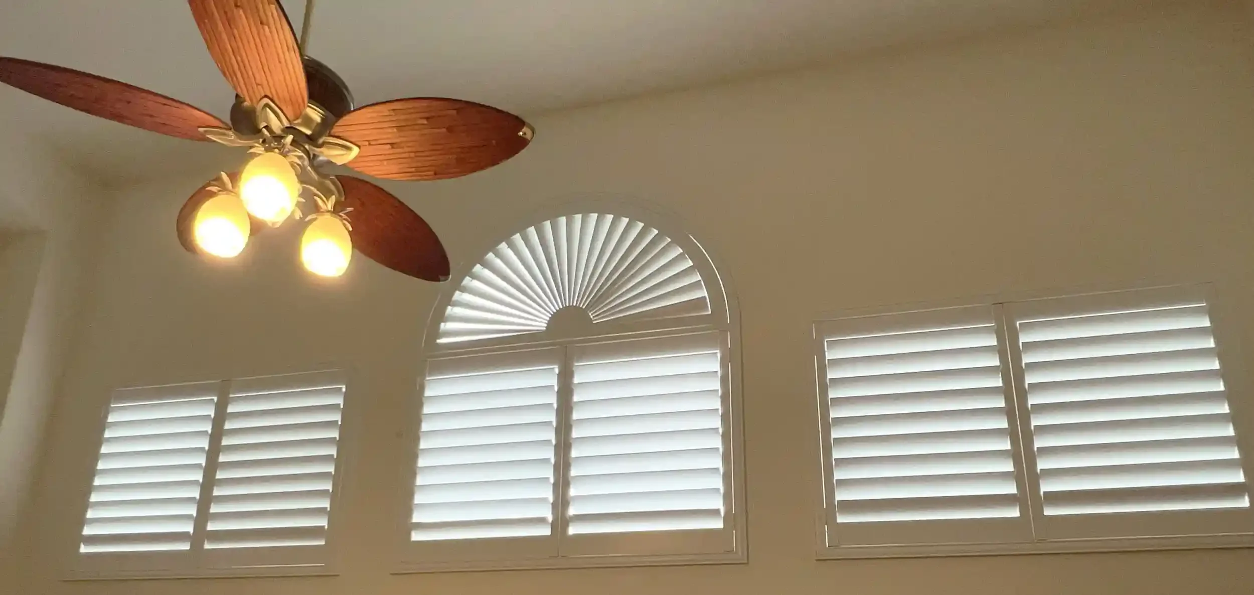 3 shutters with a sunburst shutter mounted above the center shutter