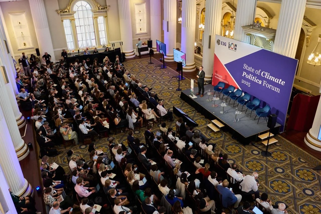 A conference room filled with seated attendees listening to a speaker on stage during the 2025 State of Climate Politics Forum.