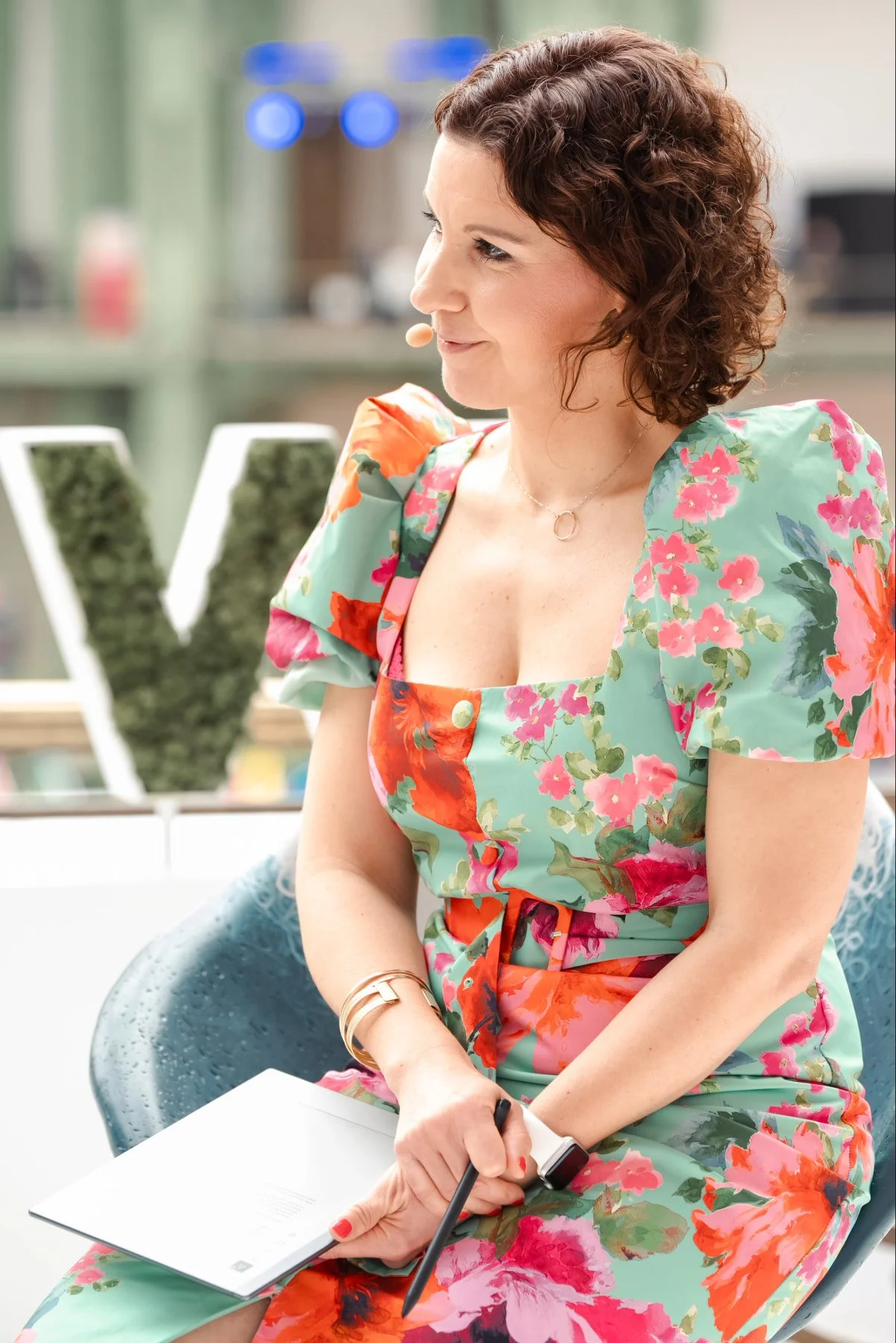 Liz in floral dress moderating plastic panel at ChangeNOW 2026