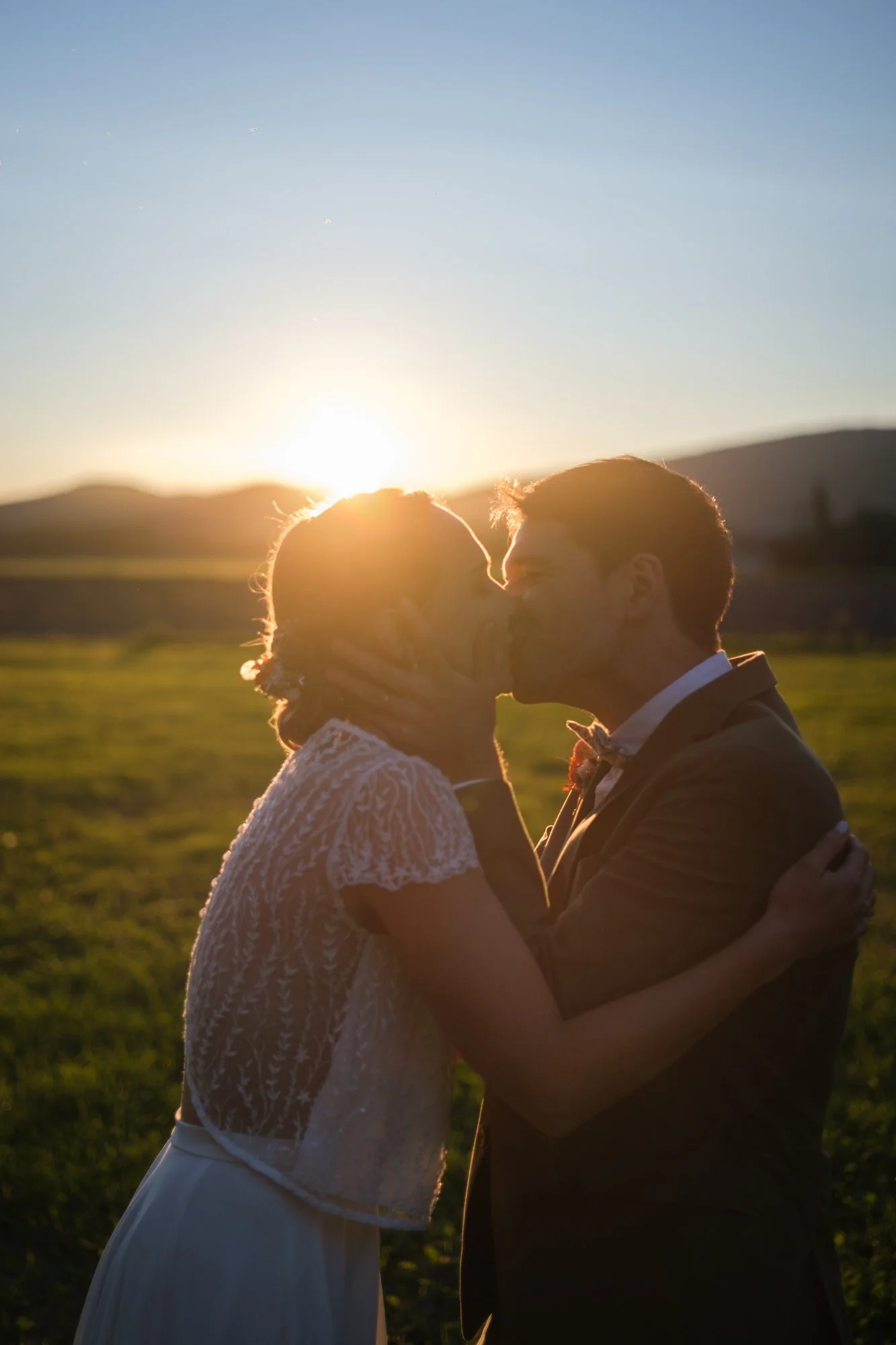 Un couple de mariés s'embrassant à la golden hour dans les alpes