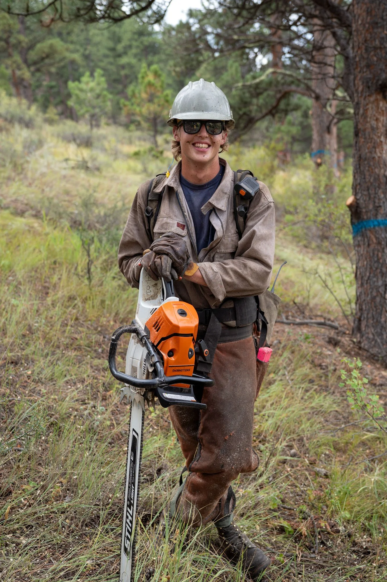 A firefighter poses for a portrait while felling trees during a forest thinning/wildfire mitigation project along a road near Red Feather Lakes in Larimer County, Colorado.