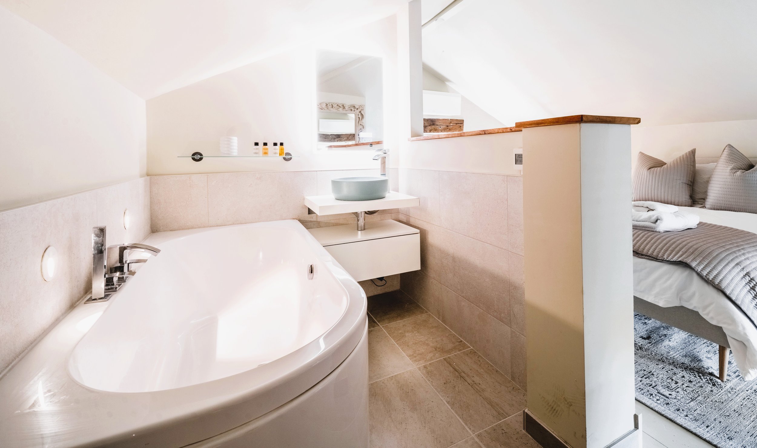 Our cottage in Langham  a modern bedroom with an open bathroom area, fully air condtioned, a wireless speaker in the mirror perfect for relaxing.