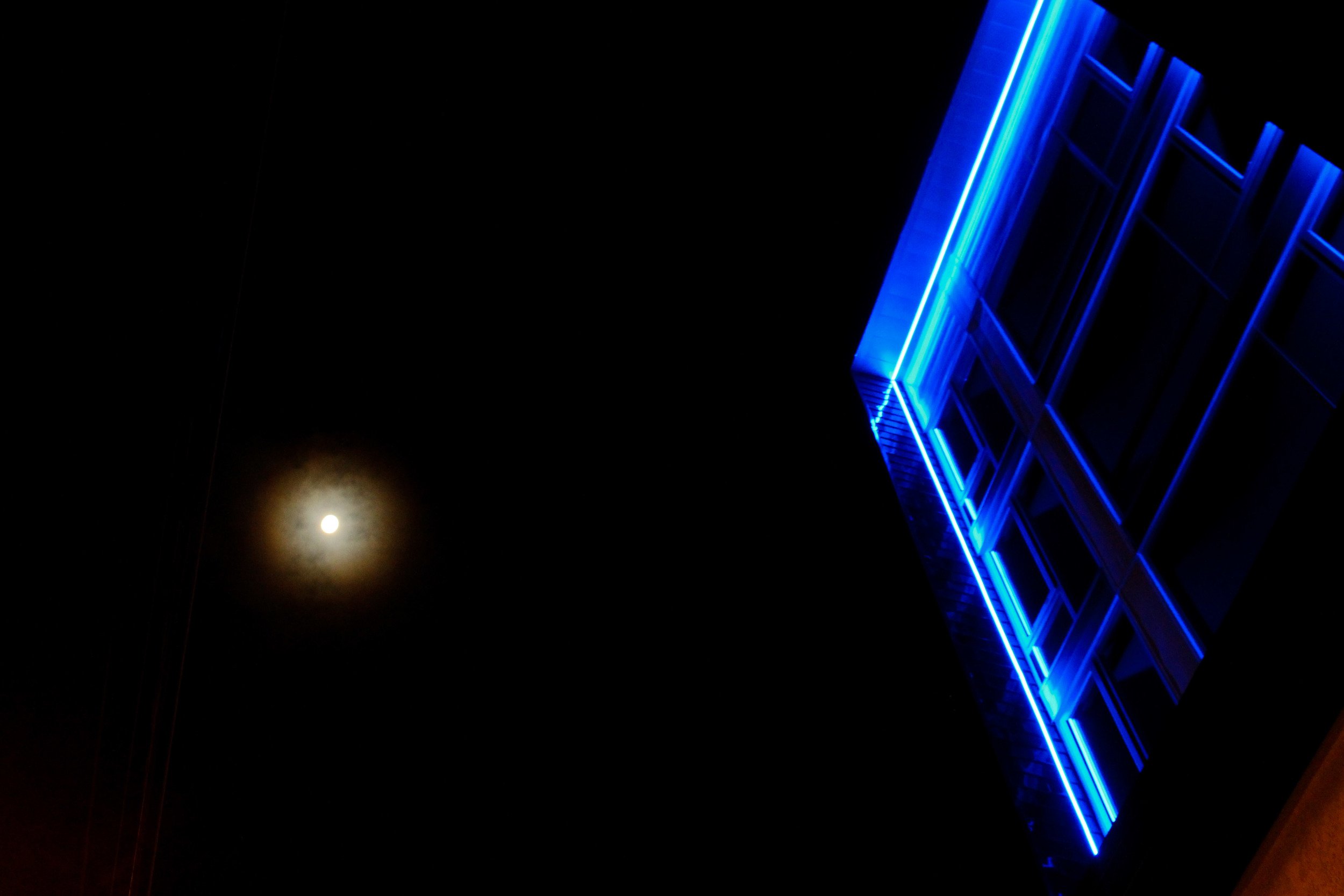 cpr blog post photo - blue neon lights on seattle apartment with moon in background.jpeg