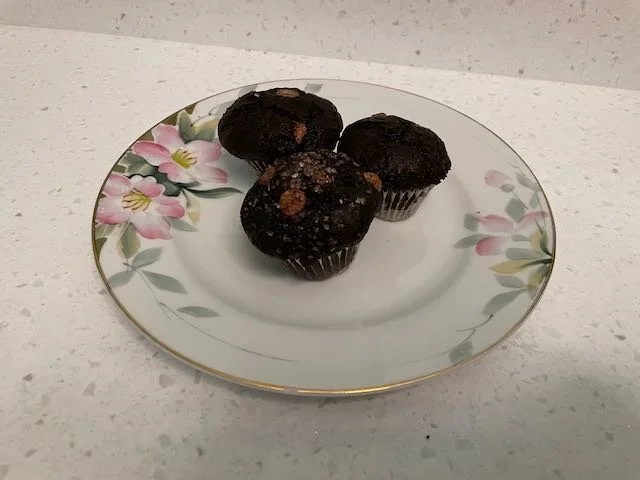 Double chocolate chip muffins on a floral china plate.