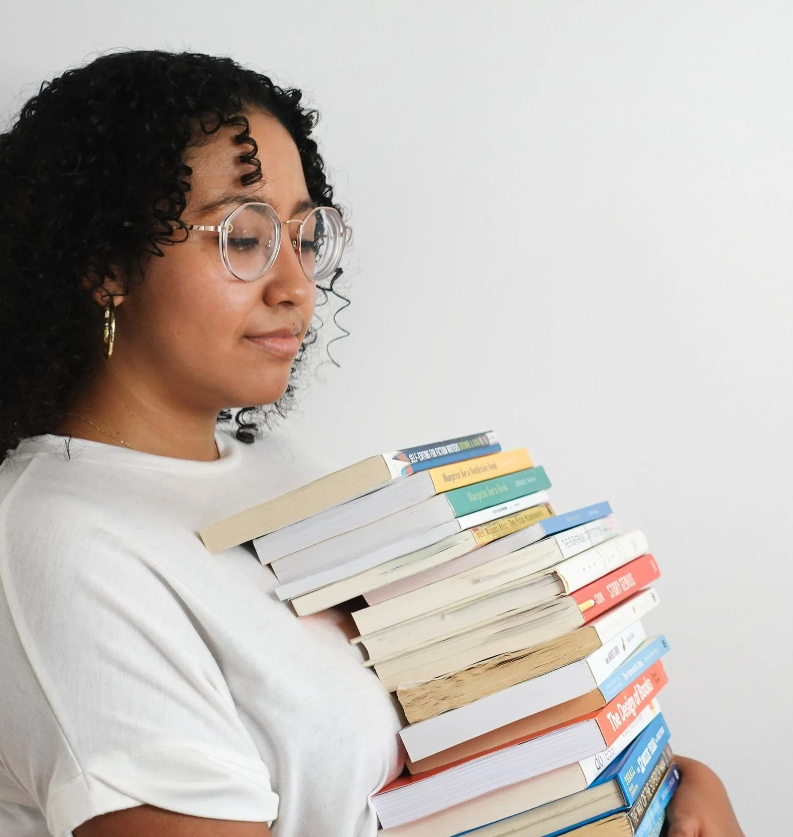Book coach Sabrina carries a stack of books.