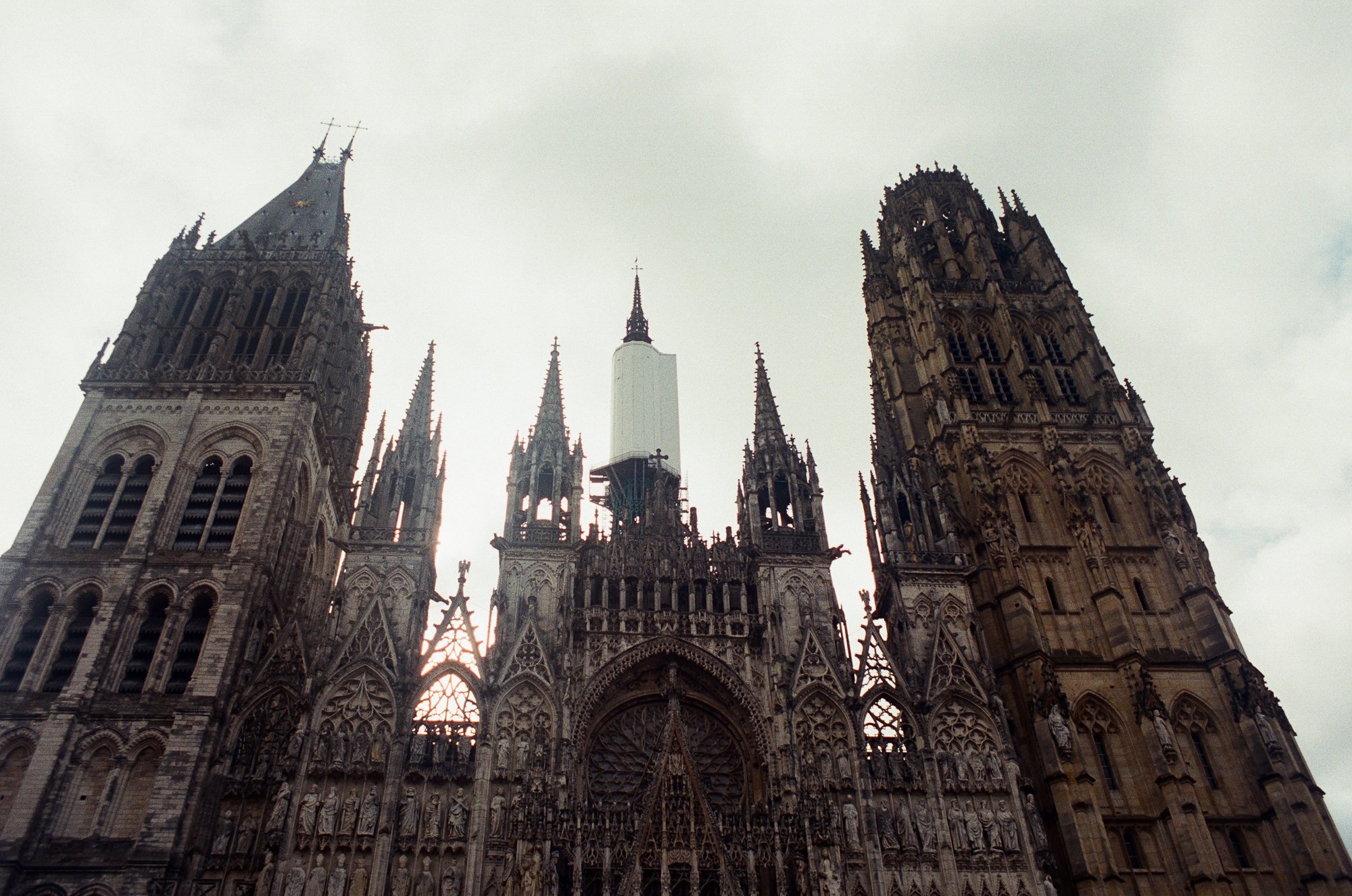 View of the Gothic-style exterior of Westminster Abbey, a historic church in London, with tall spires and intricate carvings on the facade.