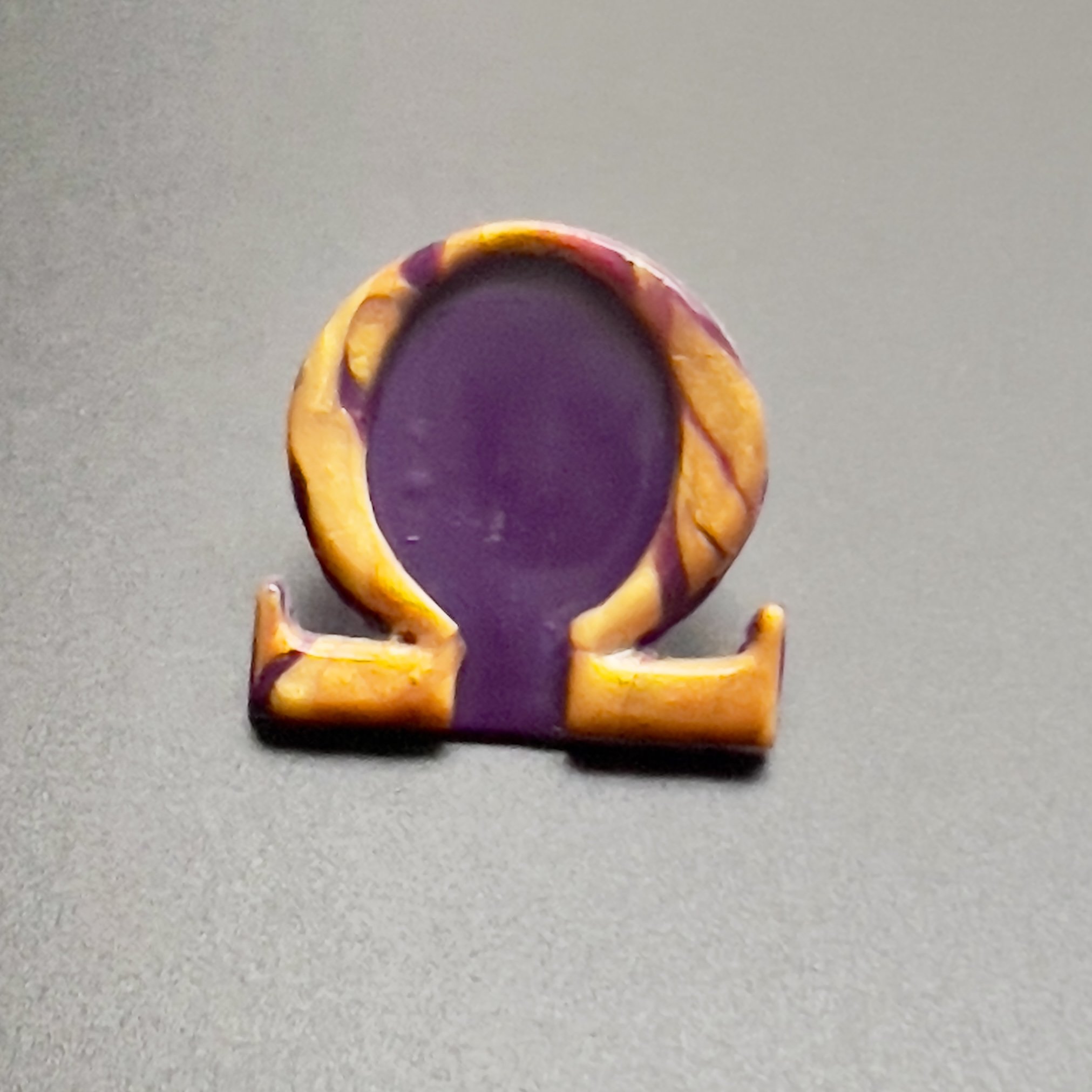 Purple and gold Omega lapel pin