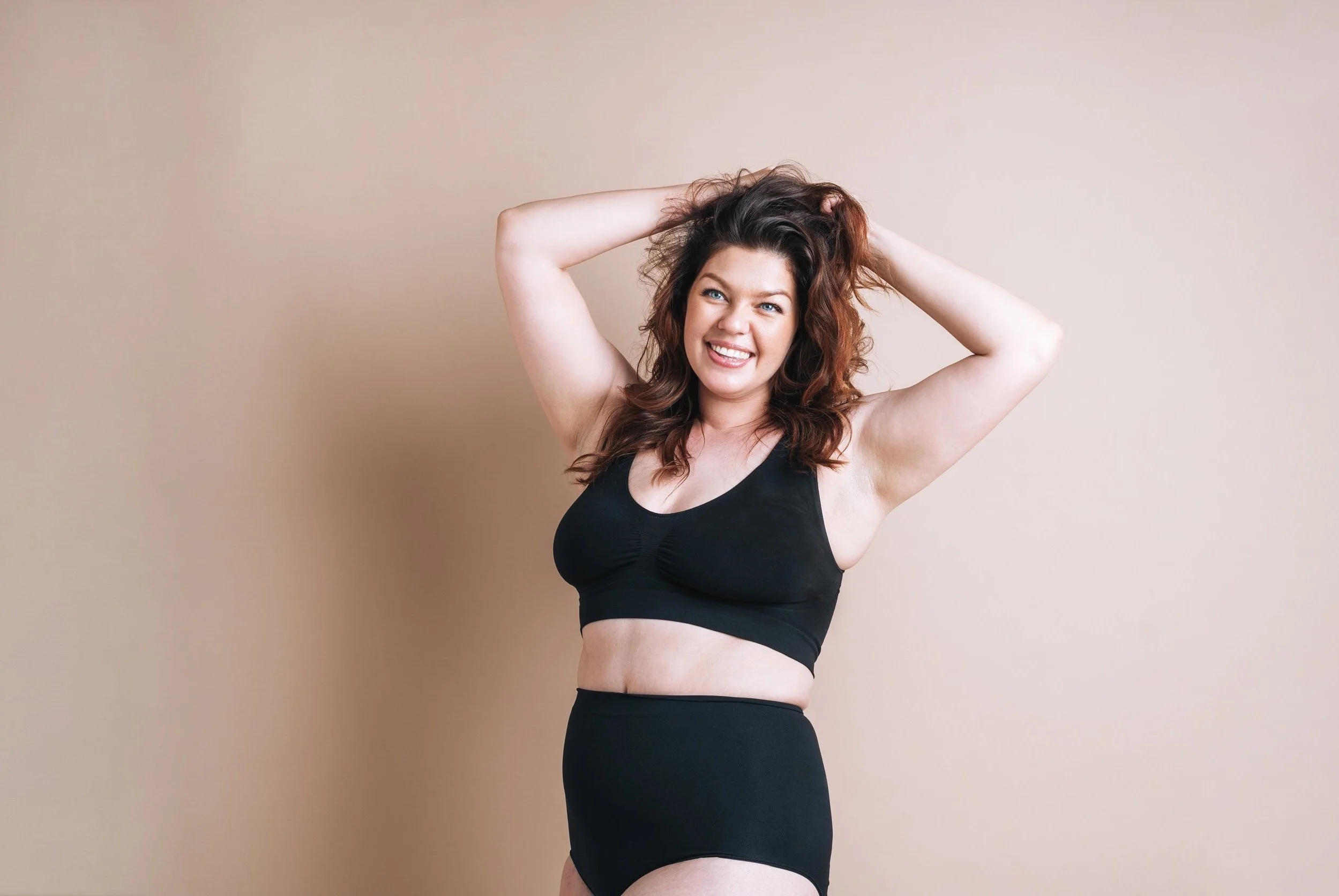 Confident woman smiling and lifting her arms