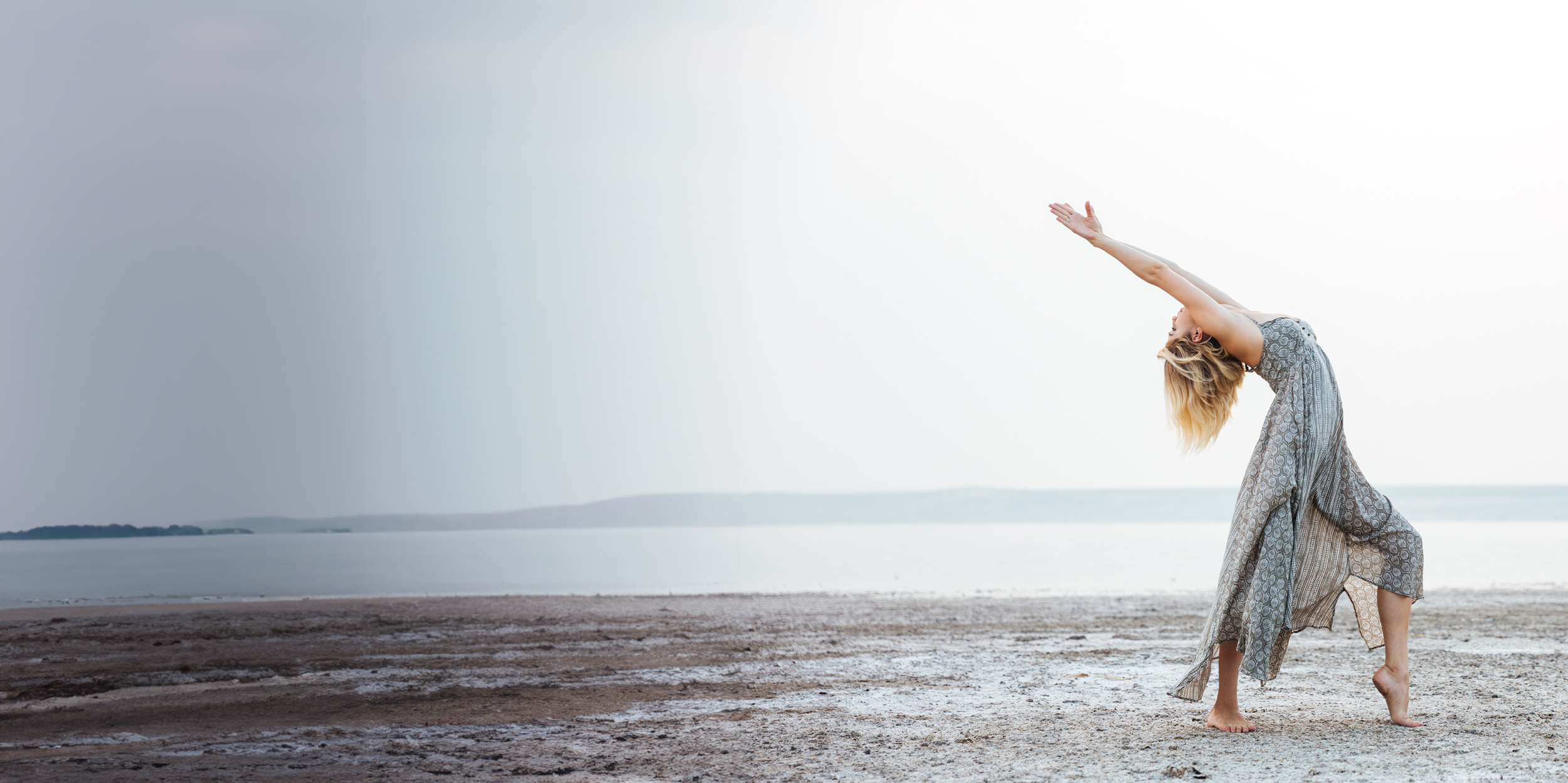 Woman in a flowing dress dancing on a beach