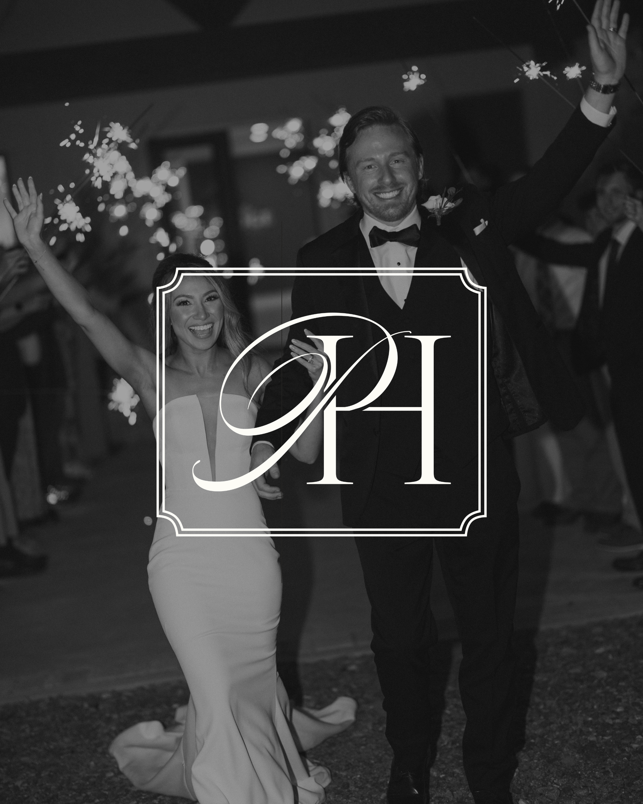 A smiling man in a tuxedo holding hands with a woman in a white dress, celebrating with sparklers in a festive setting.