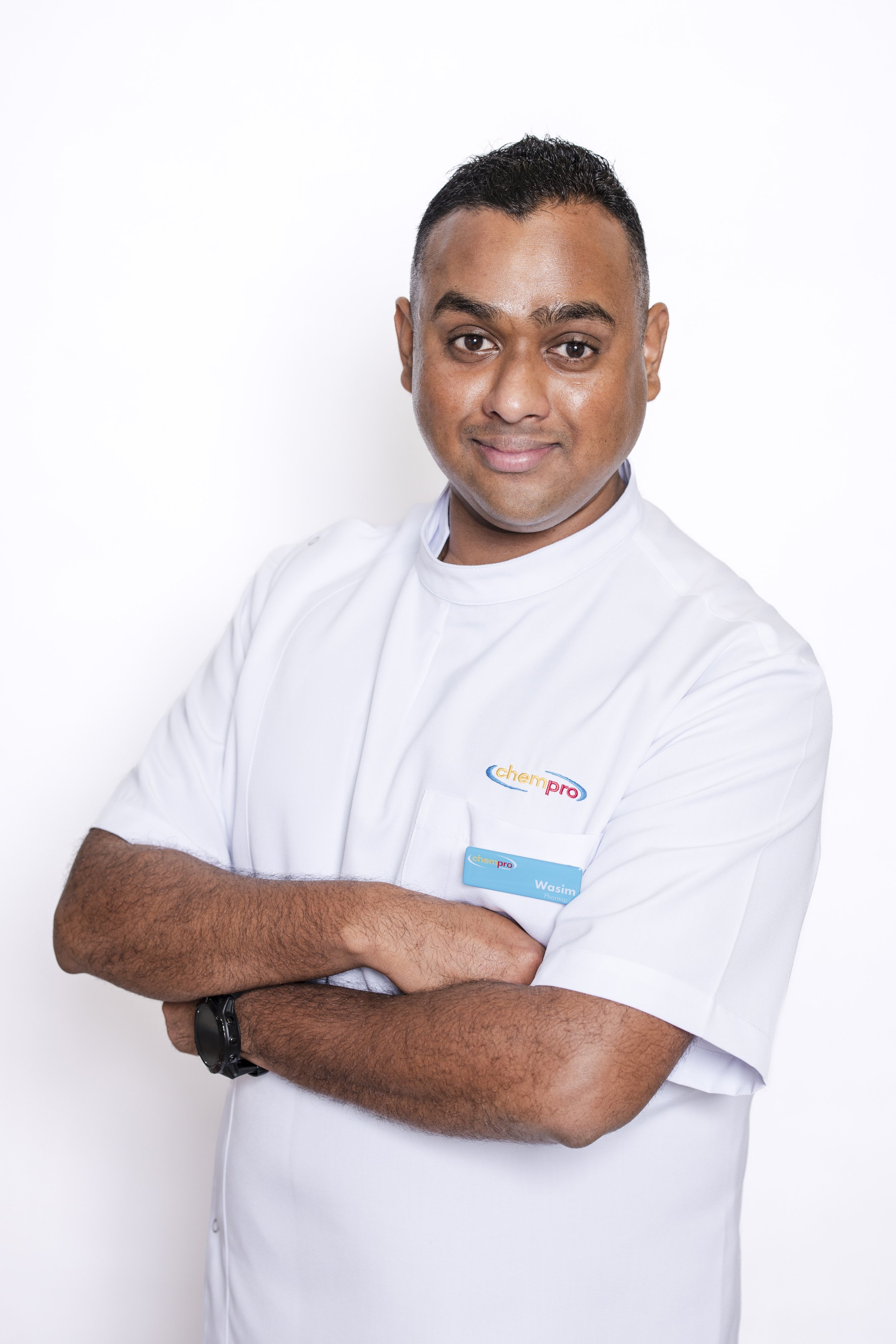A man in a white medical uniform with the 'chempro' logo, arms crossed, wearing a watch, standing against a white background.