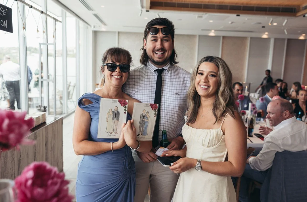 2 guests sharing their illustrations by Belinda Xia at a wedding