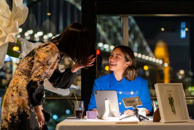 Live Illustrator Belinda Xia speaking with a client at an illustration event