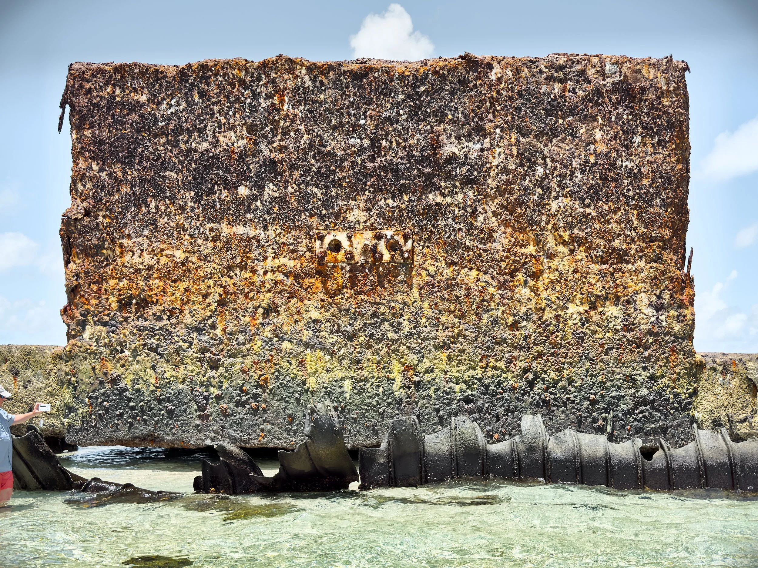  Bill measuring radiation on a wall of blistered and fused concrete that faced the Bravo device as it exploded. The portholes in the middle were intended for cameras but were destroyed by the intensity of the blast that also vaporized an adjacent isl