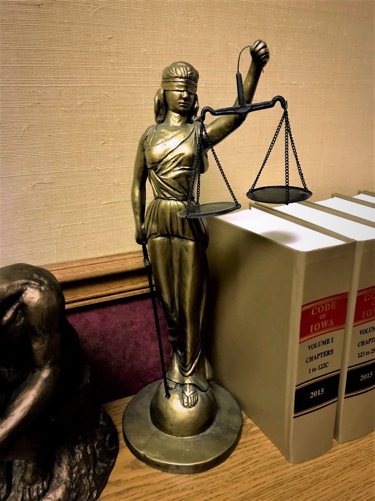 Statue of lady justice next to legal reference texts