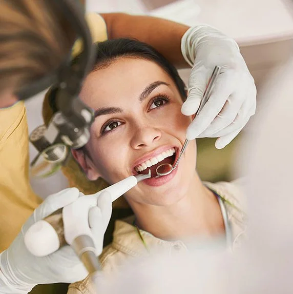 Brunette woman sitting in dental hygienist chair  having airflow clean and polish at megan Fairhall dental in bournemouth.