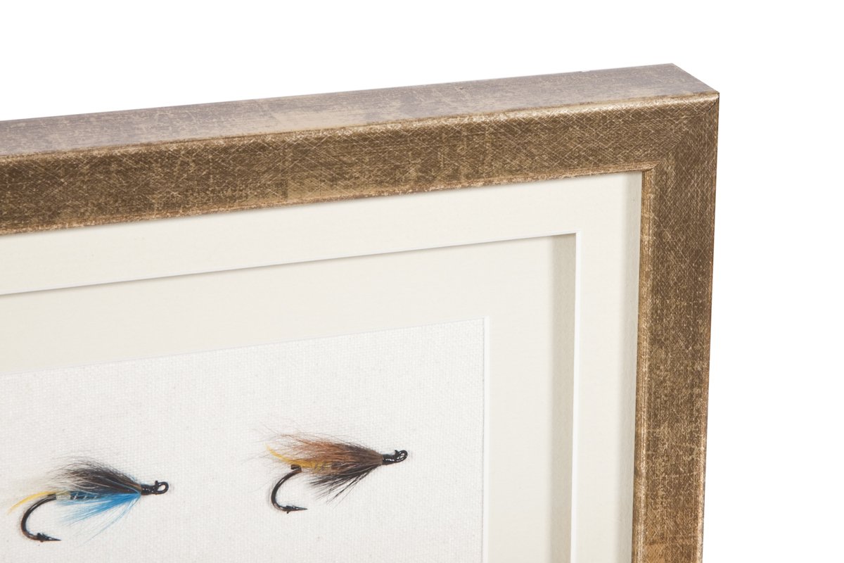 Close-up of a framed display featuring two fishing flies with hooks.