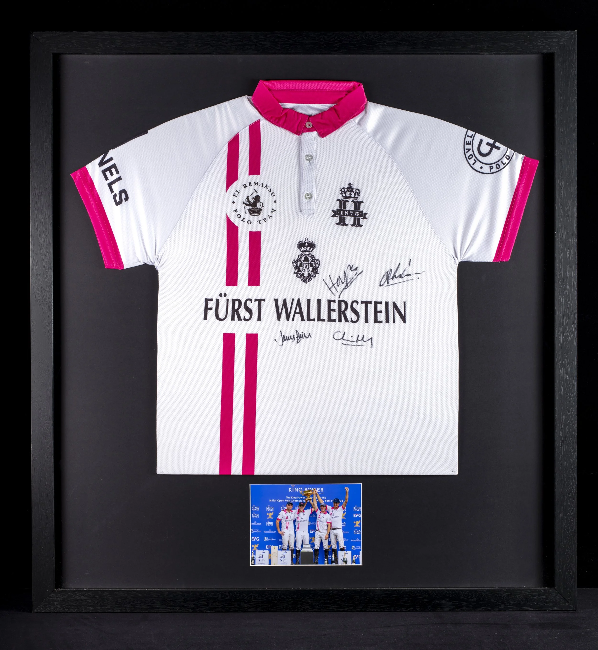 Framed display of a soccer team holding a trophy, with a backdrop. Above it, a signed sports jersey with logos and signatures, framed as memorabilia.