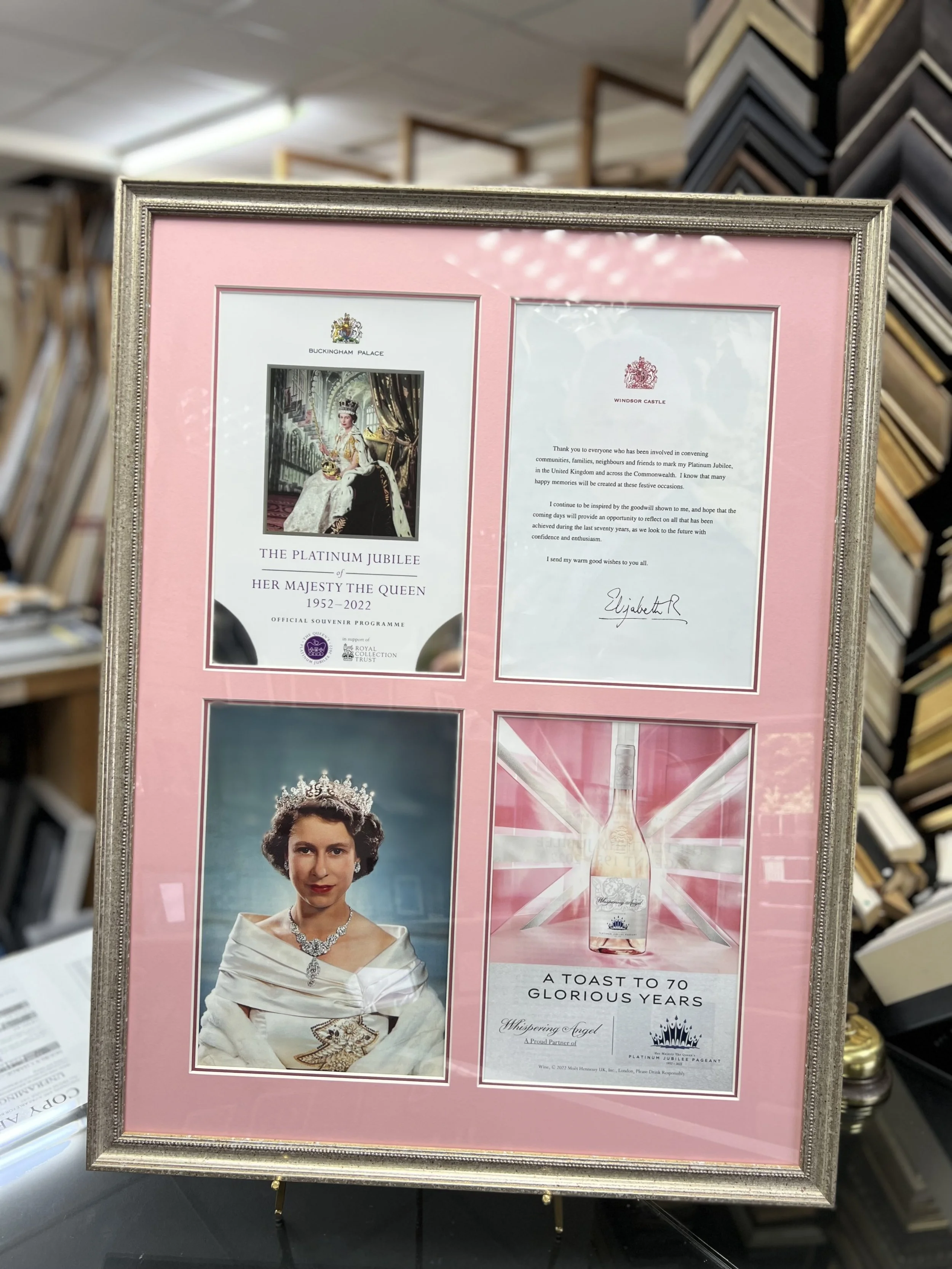 A framed collage celebrating Queen Elizabeth II's Platinum Jubilee, featuring a royal portrait, a message of thanks, and a bottle of commemorative gin with Union Jack design.