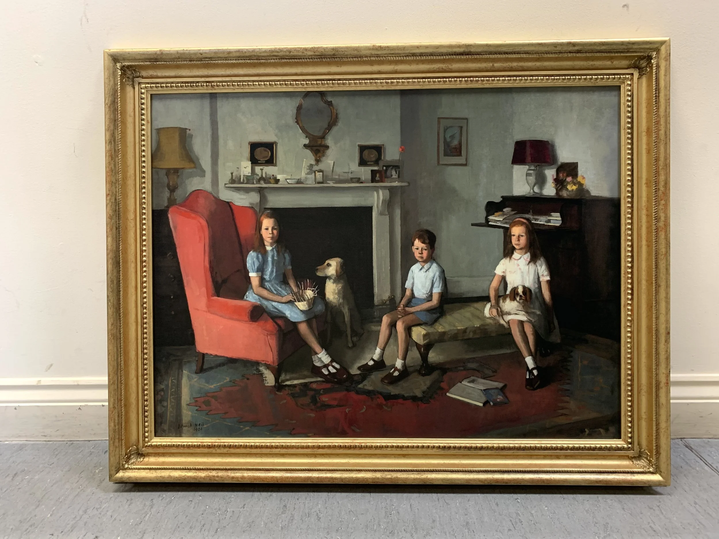 A framed painting depicts four children sitting in a living room with two dogs, one sitting beside a girl with red hair and another lying on the floor, while a fireplace, mirror, and various objects adorn the room.
