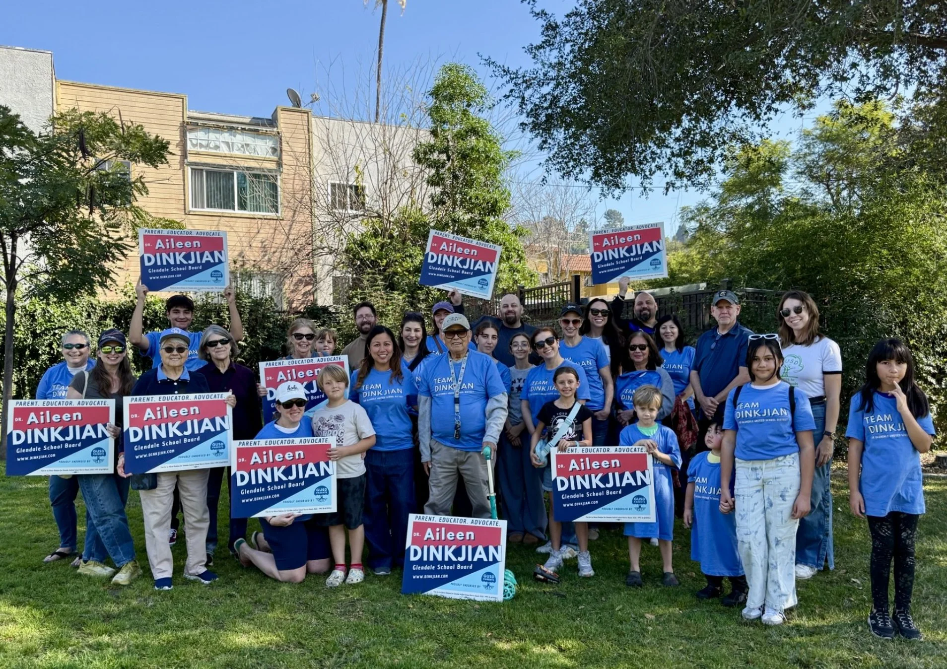 parents students and neighbors supporting local school board candidate aileen dinkjian in blue shirts in a park