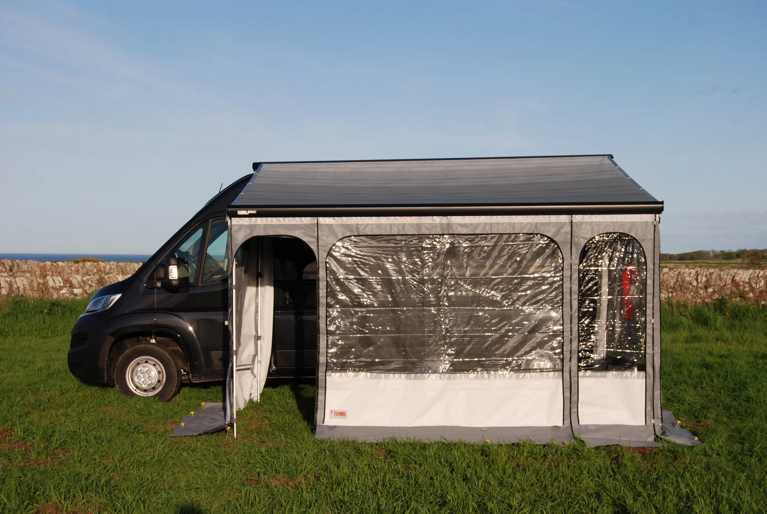 Citroen relay van with awning and privacy room against blue sky
