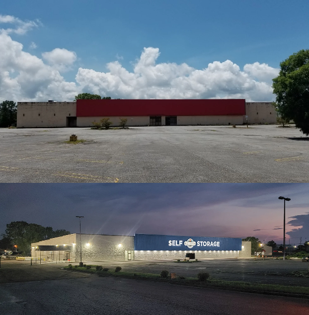 Empty parking lot with two commercial buildings, the top building is a plain beige structure with a red stripe, and the bottom building is a self storage facility with a blue and white sign and bright exterior lighting at dusk.