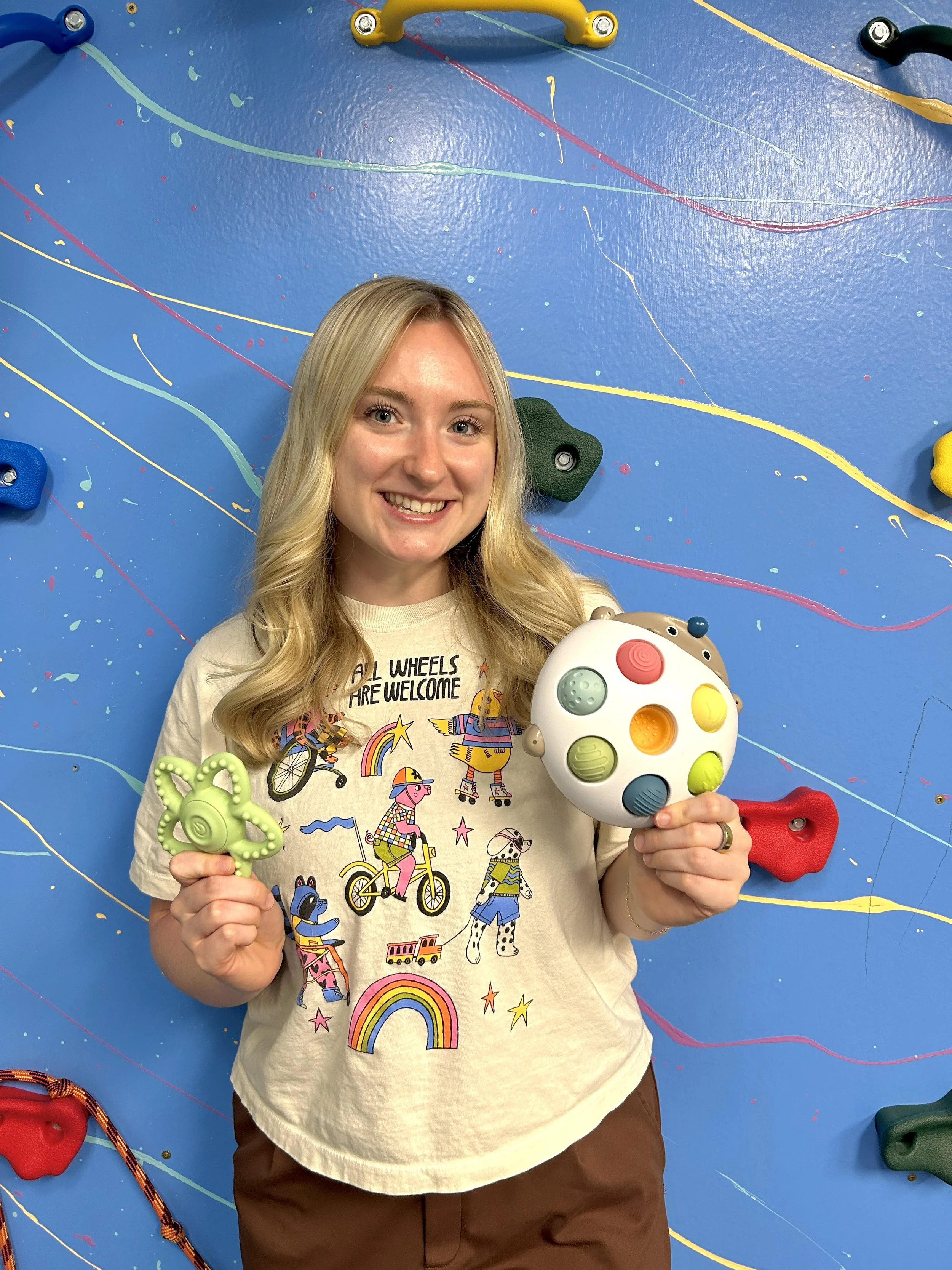 Occupational Therapist standing in front of Sensory Gym Wall at Reach for Speech