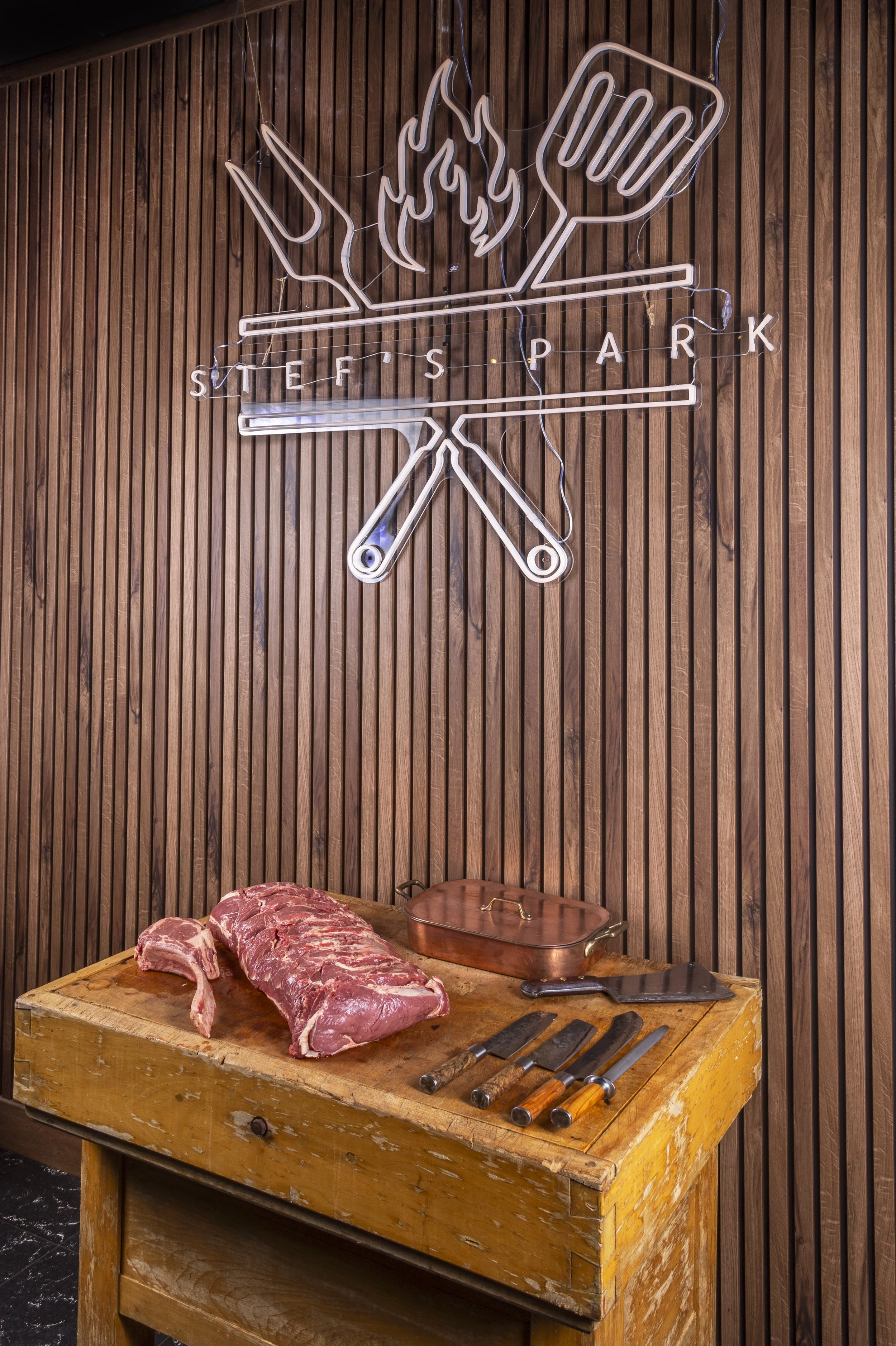 Rauw vlees en barbecuegereedschap op een houten kapblok voor een barbecue.