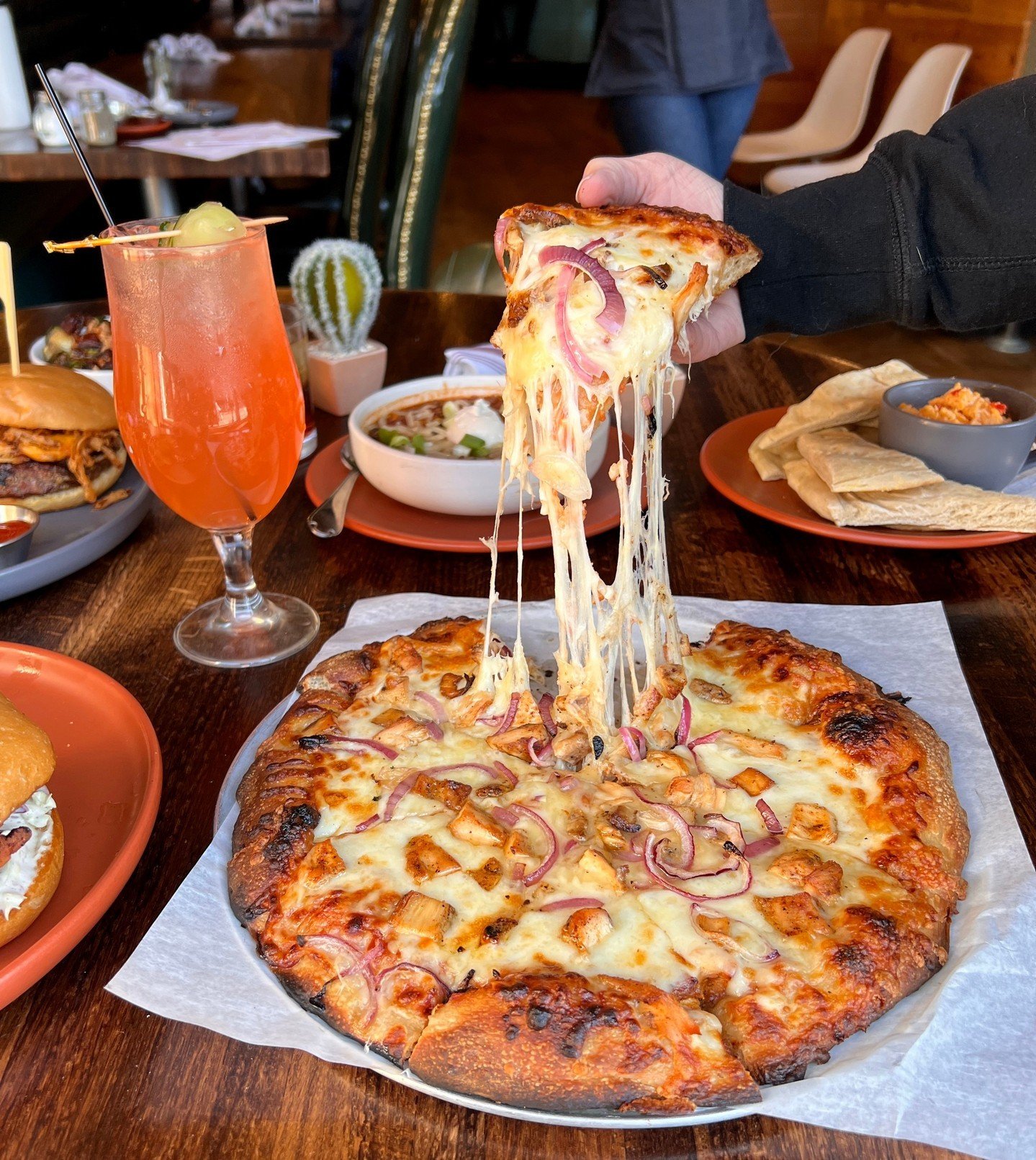 When the cheese pull looks this good, you know your pizza is going to be 🔥

Pictured is our barbecue chicken pizza made with bbq sauce, grilled brined chicken breast, sliced red onion, mozzarella &amp; white cheddar. 

We're open for lunch and dinne